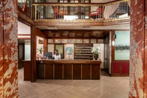 Elegant lobby with wooden reception desk, marble columns and classic décor, welcoming atmosphere in central Pisa - Hotel La Pace, BZAR hotels in Pisa
